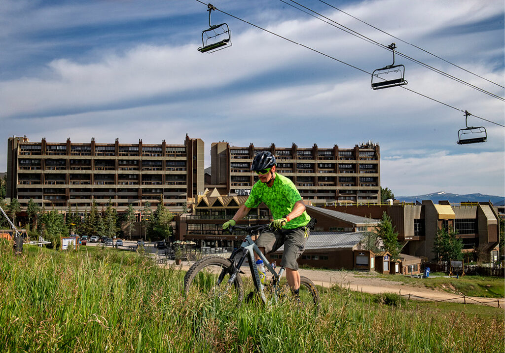 mountain biker riding up the burro trail with Beaver Run in the background