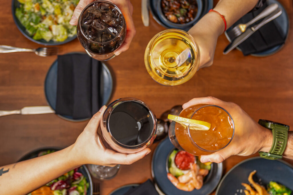 people enjoying nice drinks over a table with food