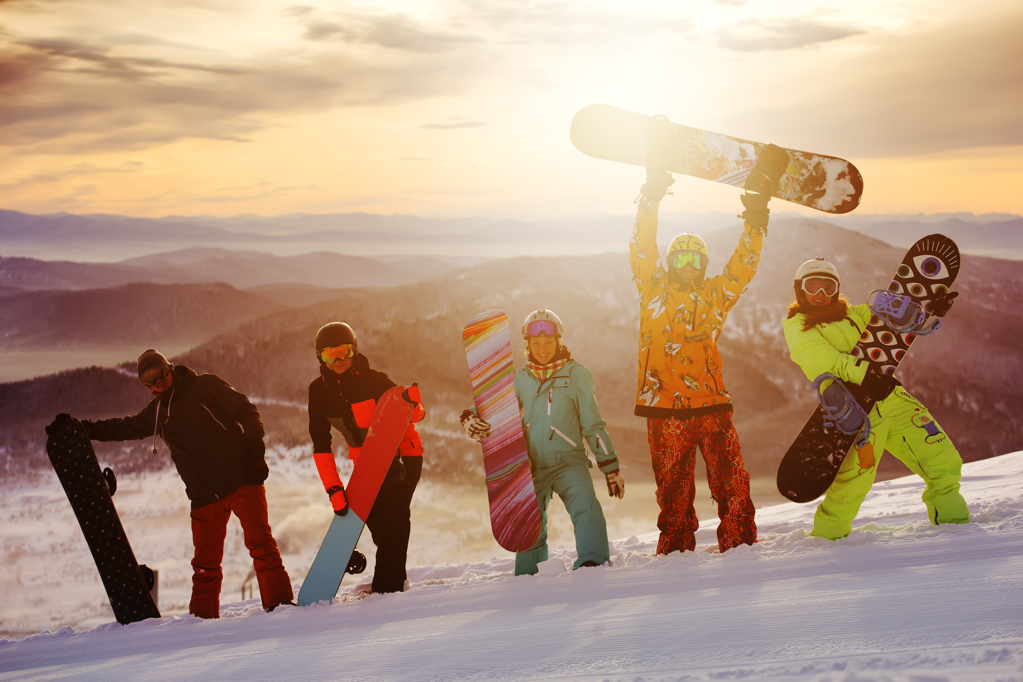 snowboarders happy on top of a mountain